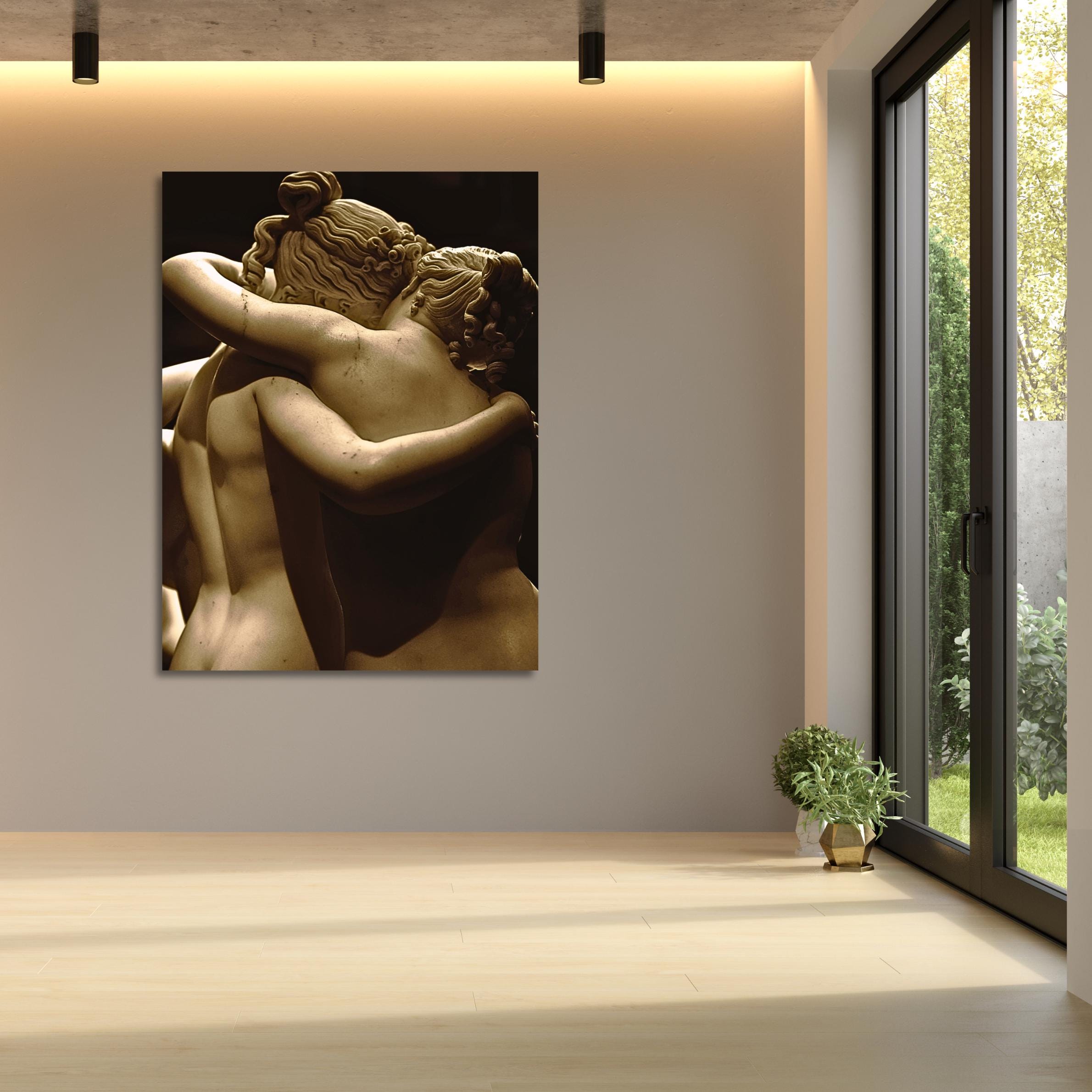 Sepia-toned photo of classical sculpture with embracing nude forms.