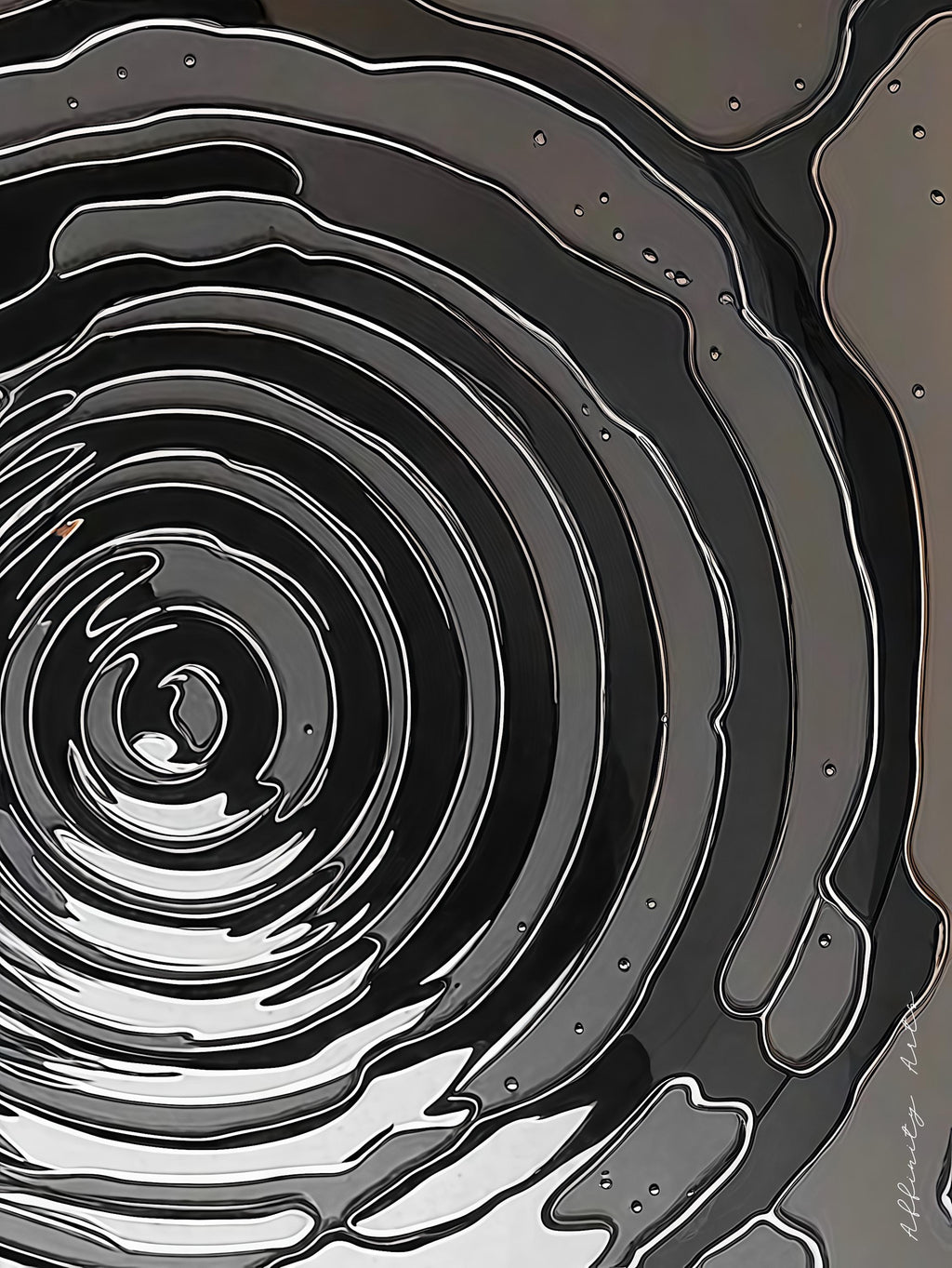 Monochrome layered paper cut art depicting water ripples or geological formations
