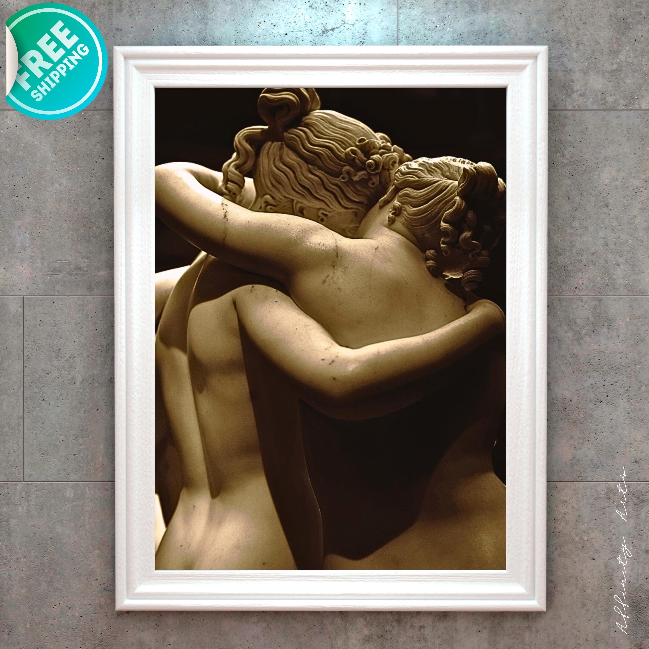 Close-up of marble sculpture showing two nude figures embracing from behind.